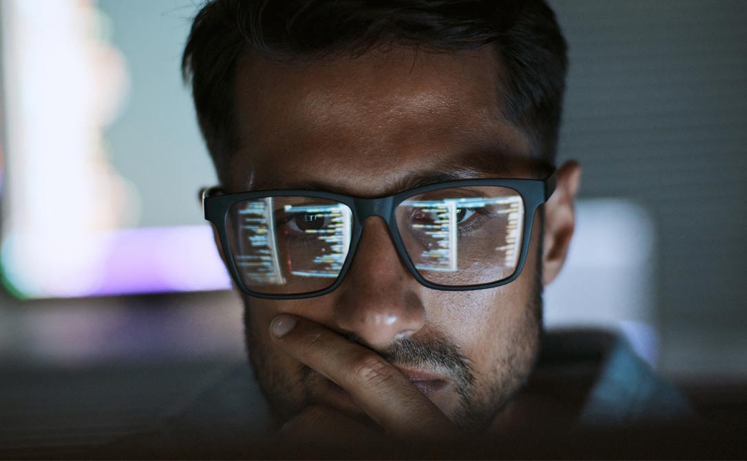 Developer looking at code, reflected in his glasses